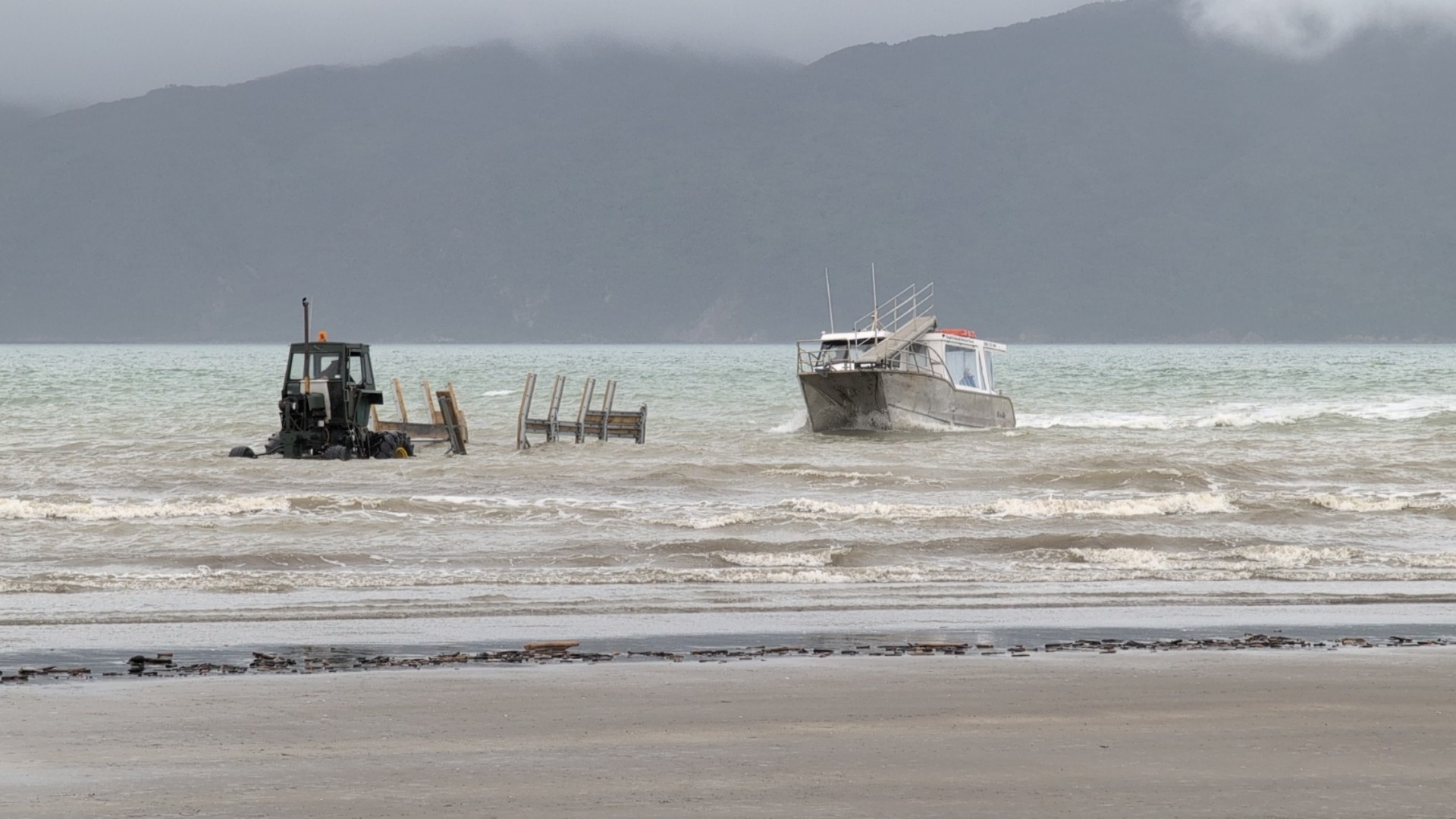Kapiti Island Nature Tours boat docking on Paraparaumu beach with a tractor